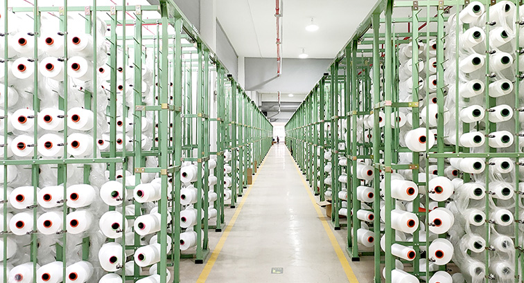 Textile yarn spools arranged along a production line
