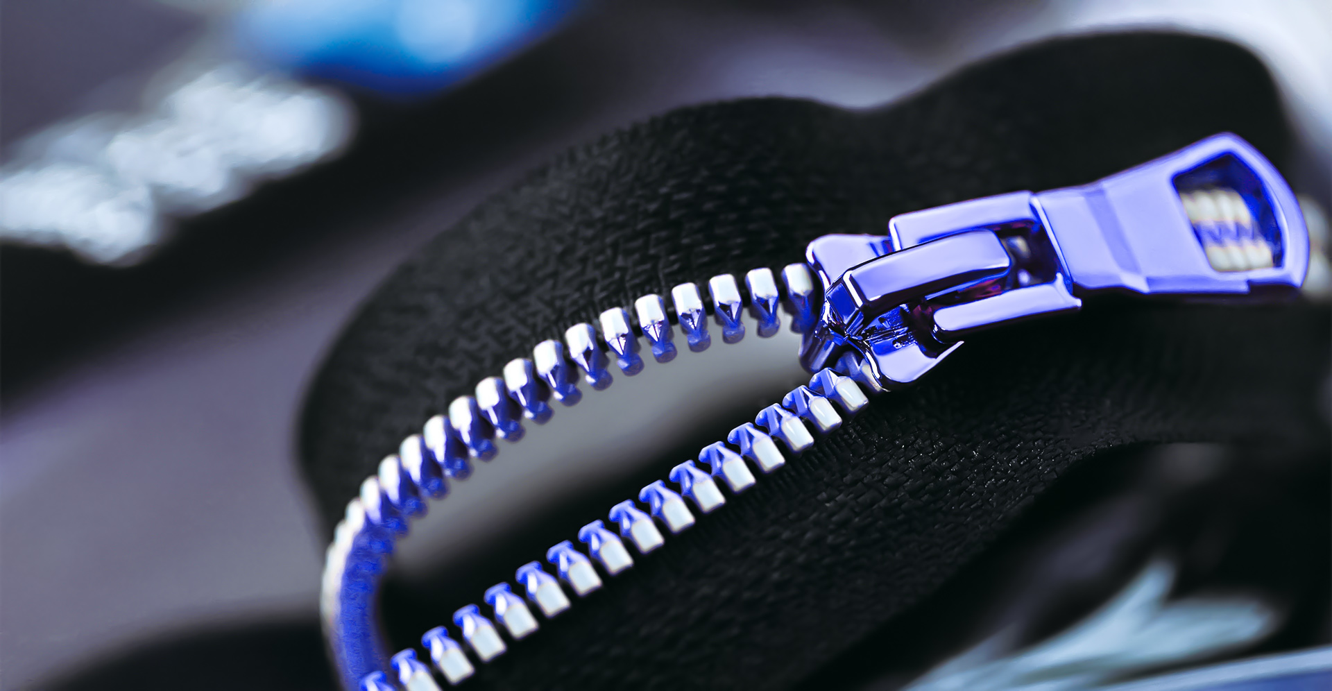 Close-up of a precision metal zipper on black fabric